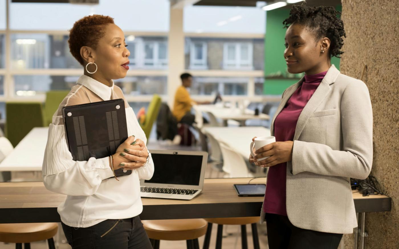 two women standing next to each other in front of a laptop by UK Black Tech courtesy of Unsplash.