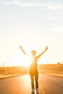 person raising both hands doing peace sign hand gesture on road during daytime by Wesley Eland courtesy of Unsplash.