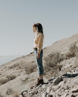 woman standing on hill by Jake Pierrelee courtesy of Unsplash.