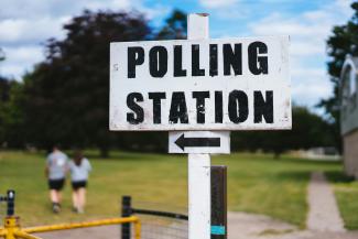 A pole with a sign that says polling station by Phil Hearing courtesy of Unsplash.