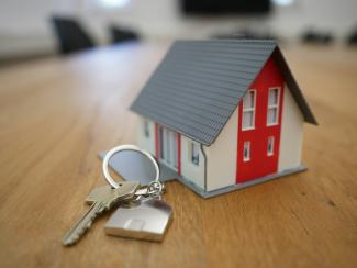 white and red wooden house miniature on brown table by Tierra Mallorca courtesy of Unsplash.