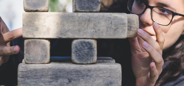 woman playing with wooden blocks by John Moeses Bauan courtesy of Unsplash.