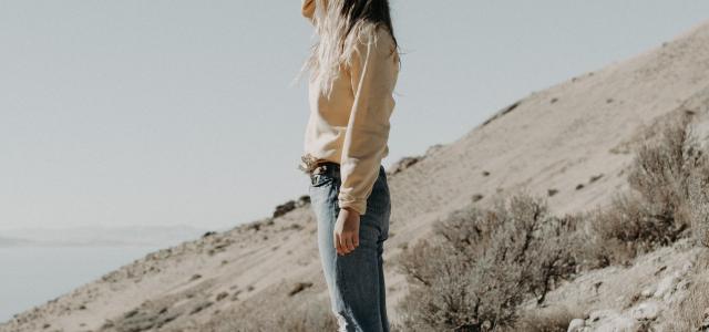 woman standing on hill by Jake Pierrelee courtesy of Unsplash.