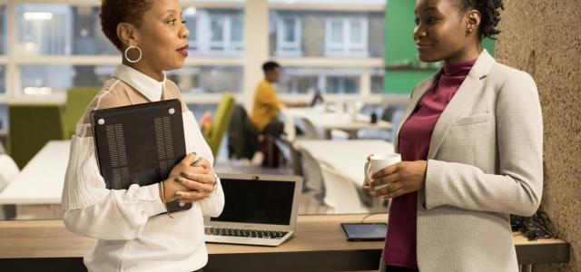 two women standing next to each other in front of a laptop by UK Black Tech courtesy of Unsplash.