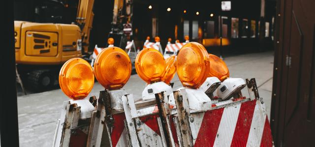 orange lights on top of white and red metal bars by Matthew Hamilton courtesy of Unsplash.