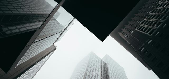 a group of tall buildings towering over a city by Louis Droege courtesy of Unsplash.